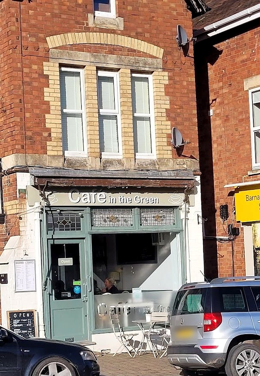 Cafe in the Green on Barnards Green Road: a sage-green shopfront under a red-brick house, with café tables and chairs on the pavement